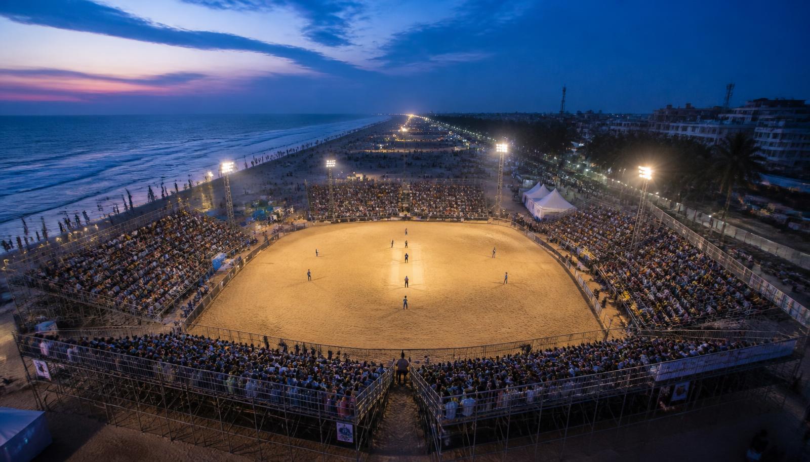 Beach cricket stadium atmosphere with packed coastal grandstands